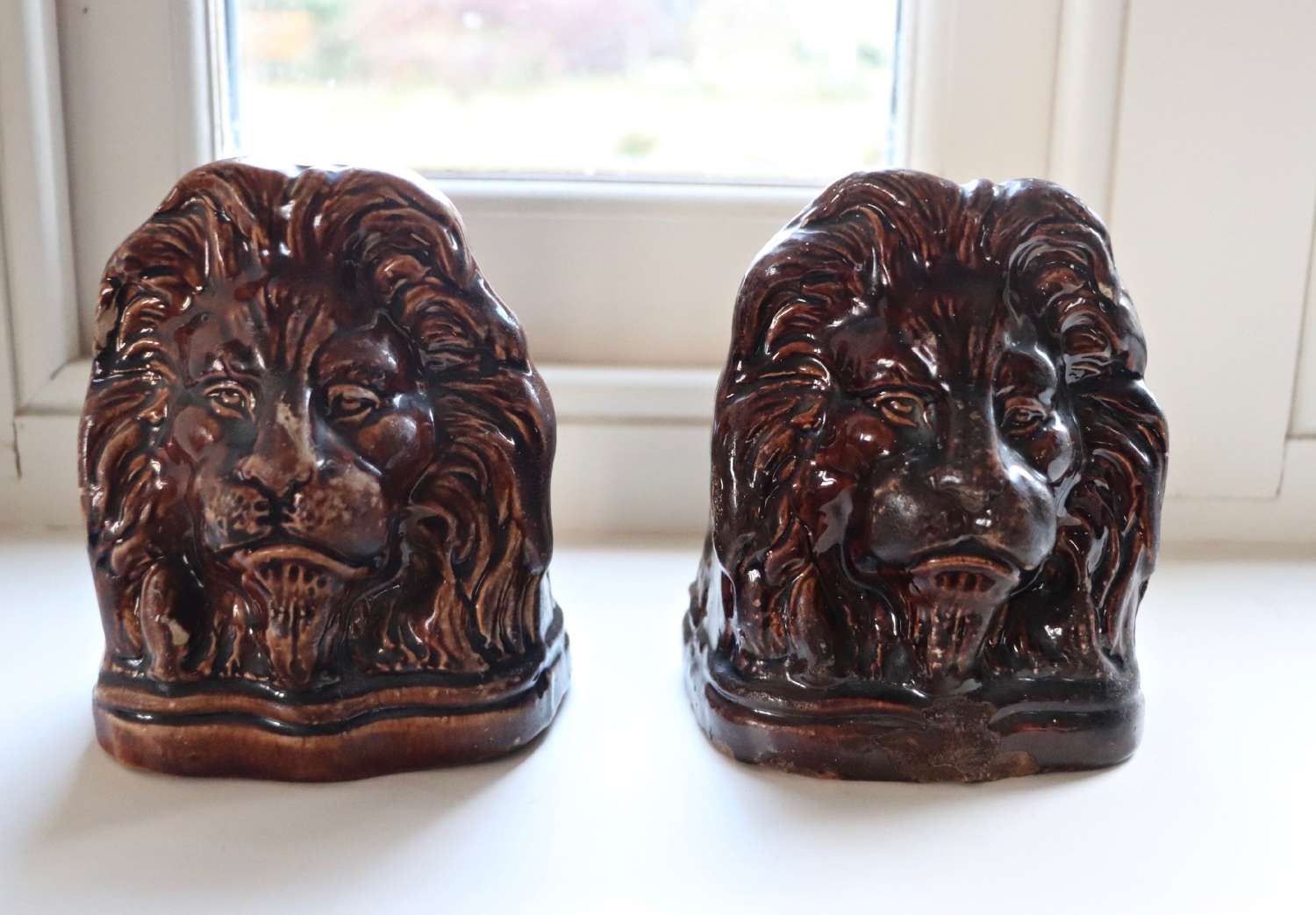 A pair of Victorian sash window stops in the form of lion heads